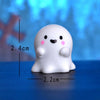 White resin craft miniature ghost decor with pink accents shown against a blue background.