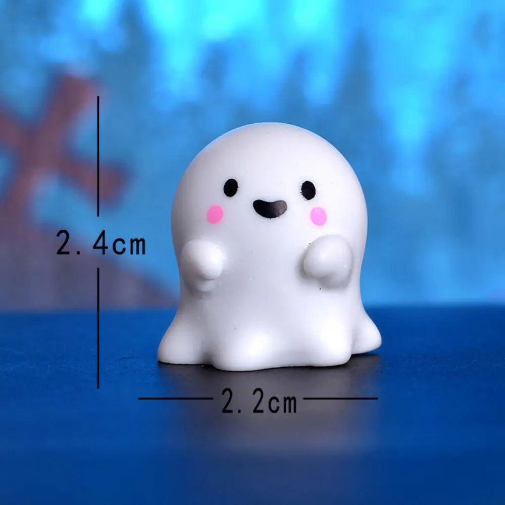White resin craft miniature ghost decor with pink accents shown against a blue background.