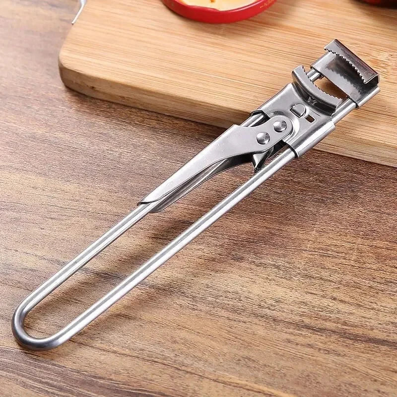 A heavy duty stainless steel bottle opener lying on a wooden cutting board.