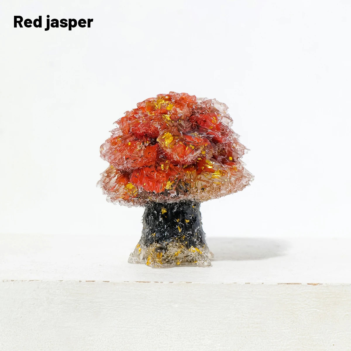 A natural crystal mushroom tree sculpture with a reddish-orange top and a dark base.