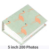 A green memory album featuring illustrations of flamingos on the cover.