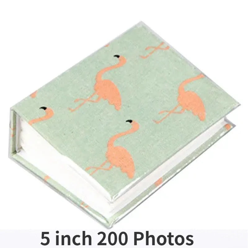 A green memory album featuring illustrations of flamingos on the cover.
