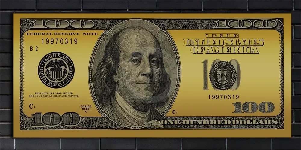 A close-up of a gold-colored United States $100 Federal Reserve Note from 1997, featuring Benjamin Franklin.