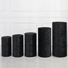 A row of black spandex cylinder stand covers, varying in height, displayed against a white paneled wall.