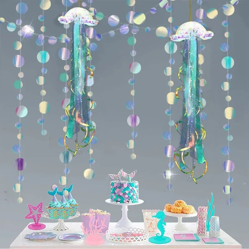 Iridescent mermaid and jellyfish party streamers hanging in a display with treats.