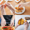 Hands wearing disposable clear plastic gloves preparing food ingredients like shrimp and fried chicken.