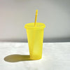 A yellow glitter party cup with a straw is shown against a white background.