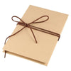 A light tan scrapbook album with a brown twine bow tied on the cover.