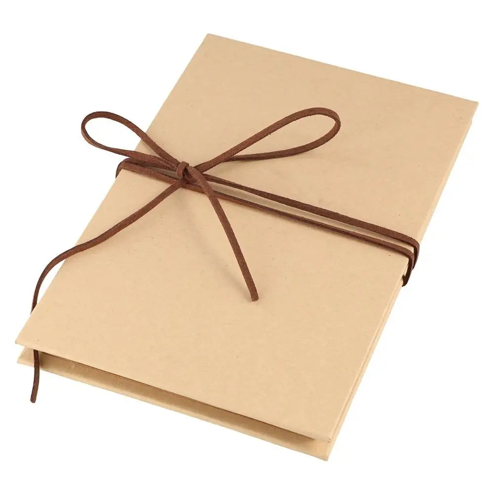 A light tan scrapbook album with a brown twine bow tied on the cover.