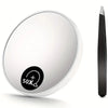 A round, white magnifying compact mirror with a suction cup and a black handle is shown.