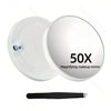 A white magnifying makeup mirror with a suction cup and a black handle is shown.