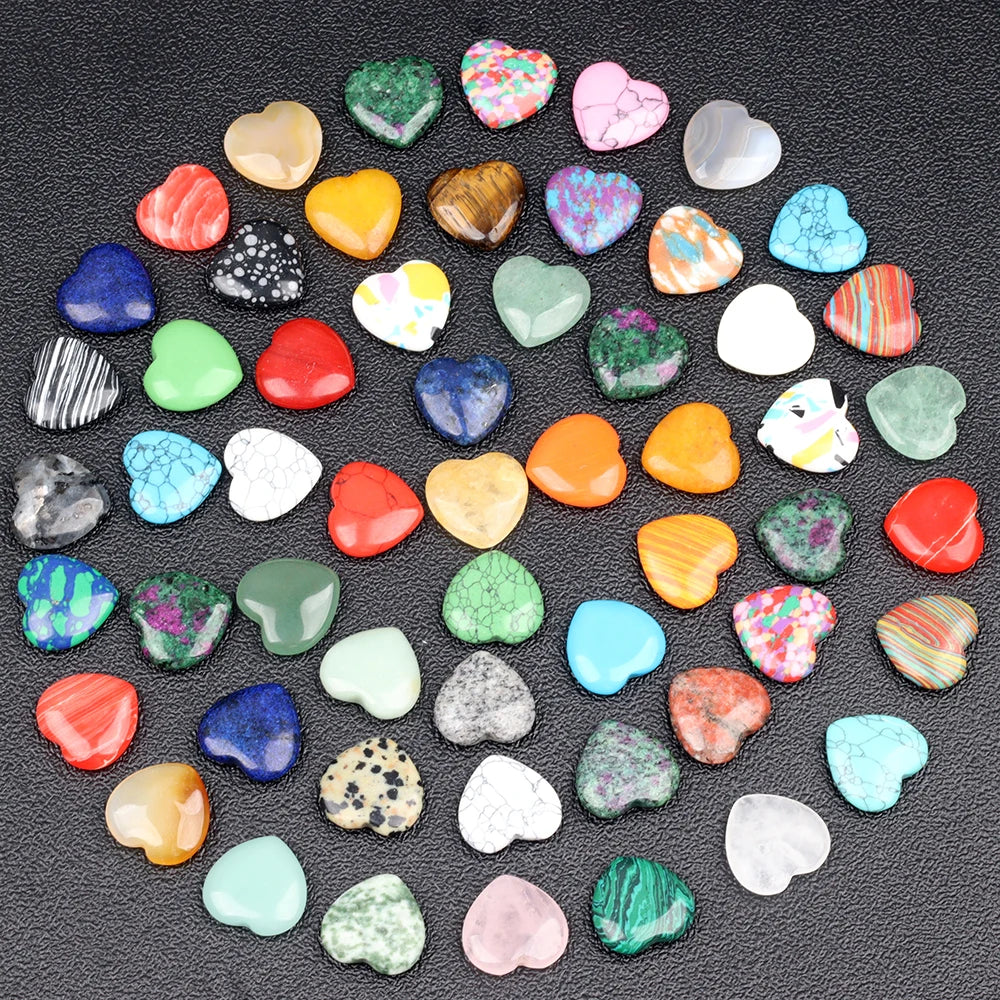 A collection of heart-shaped amethyst crystal stones in various colors and shades scattered on a dark surface.