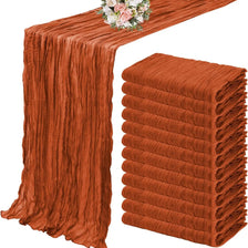 A set of ten terracotta semi-sheer cheesecloth table runners displayed on a table.
