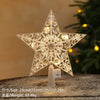 A clear crystal star ornament with a warm white glow displayed on a wooden surface.