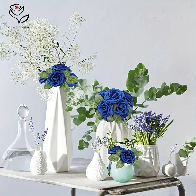 A floral arrangement featuring blue roses and white baby's breath displayed in a white vase on a wooden surface.