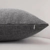 A close-up of a textured gray linen pillowcase with a visible stitching detail.
