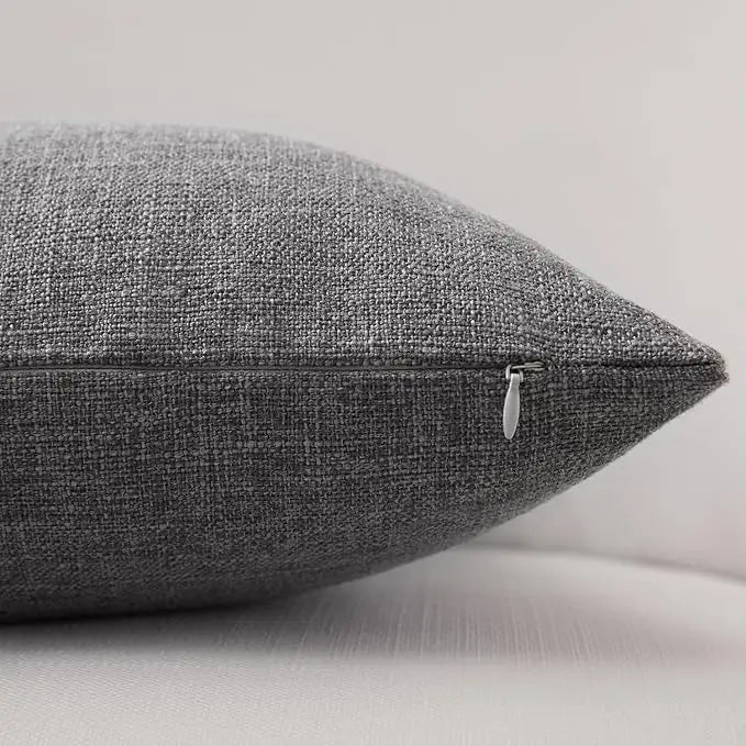 A close-up of a textured gray linen pillowcase with a visible stitching detail.