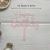 Pink acrylic birthday cake topper with happy birthday lettering and a wooden background
