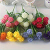 Un bouquet de fleurs d'hydrangea artificielles dans diverses nuances de rose, blanc, jaune et violet.