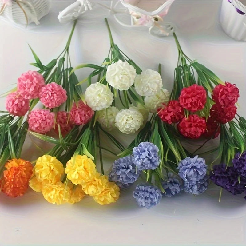 Un bouquet de fleurs d'hydrangea artificielles dans diverses nuances de rose, blanc, jaune et violet.