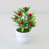 Artificial lemon tree bonsai with green leaves and red fruit planted in a white pot
