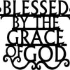 Black metal wall art sign with the text Blessed by The Grace of God in a decorative script