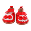 A pair of red and white fabric shoes with bow details for dolls