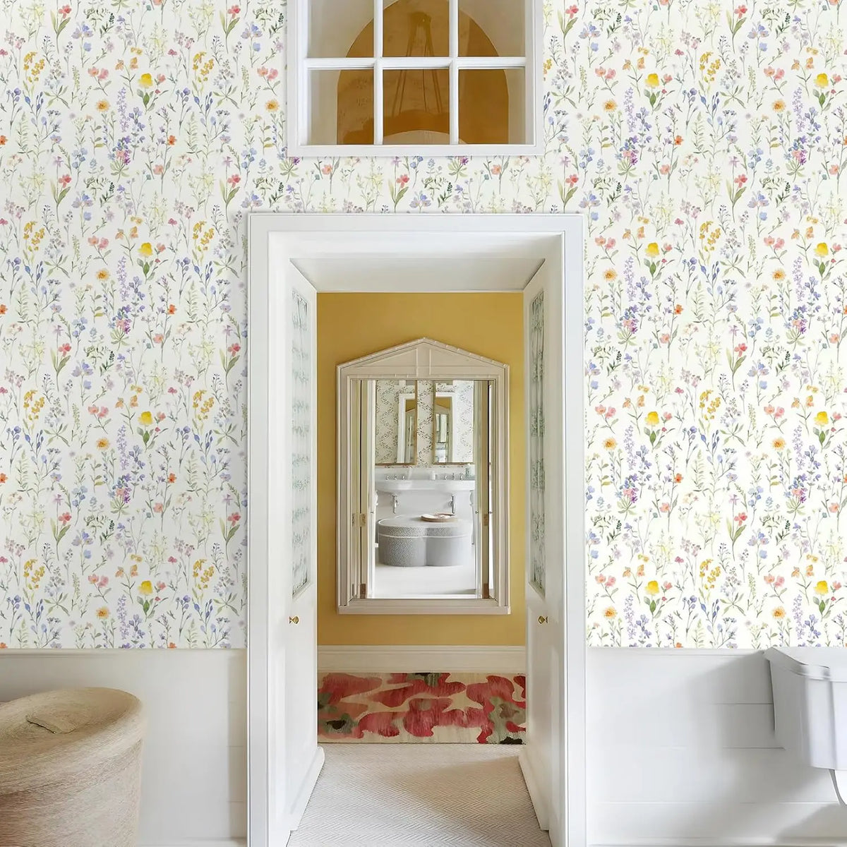 A room featuring boho floral peel and stick wallpaper on the walls, with a white framed doorway leading to another area.