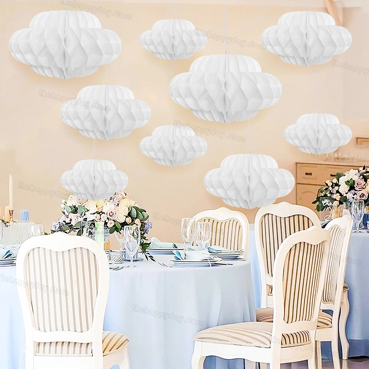 White honeycomb ball decorations shaped like clouds displayed on a table setting.