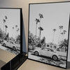 Black and white poster featuring a vintage car parked in front of palm trees and houses.