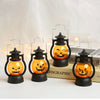 Three black hanging lanterns with orange LED pumpkins and ghost designs displayed on a white surface.