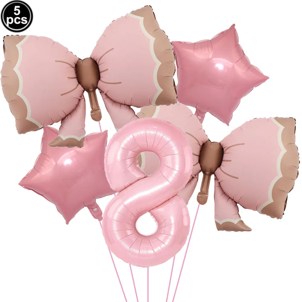 A set of pink bow shaped balloons for a disposable party tableware set