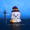 A white resin miniature ghost decor with a purple hat and yellow accents, shown against a blue background.