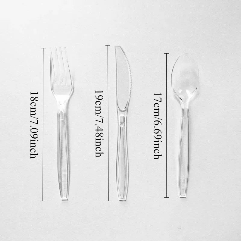 A set of clear plastic cutlery including a fork, knife, and spoon displayed against a white background.