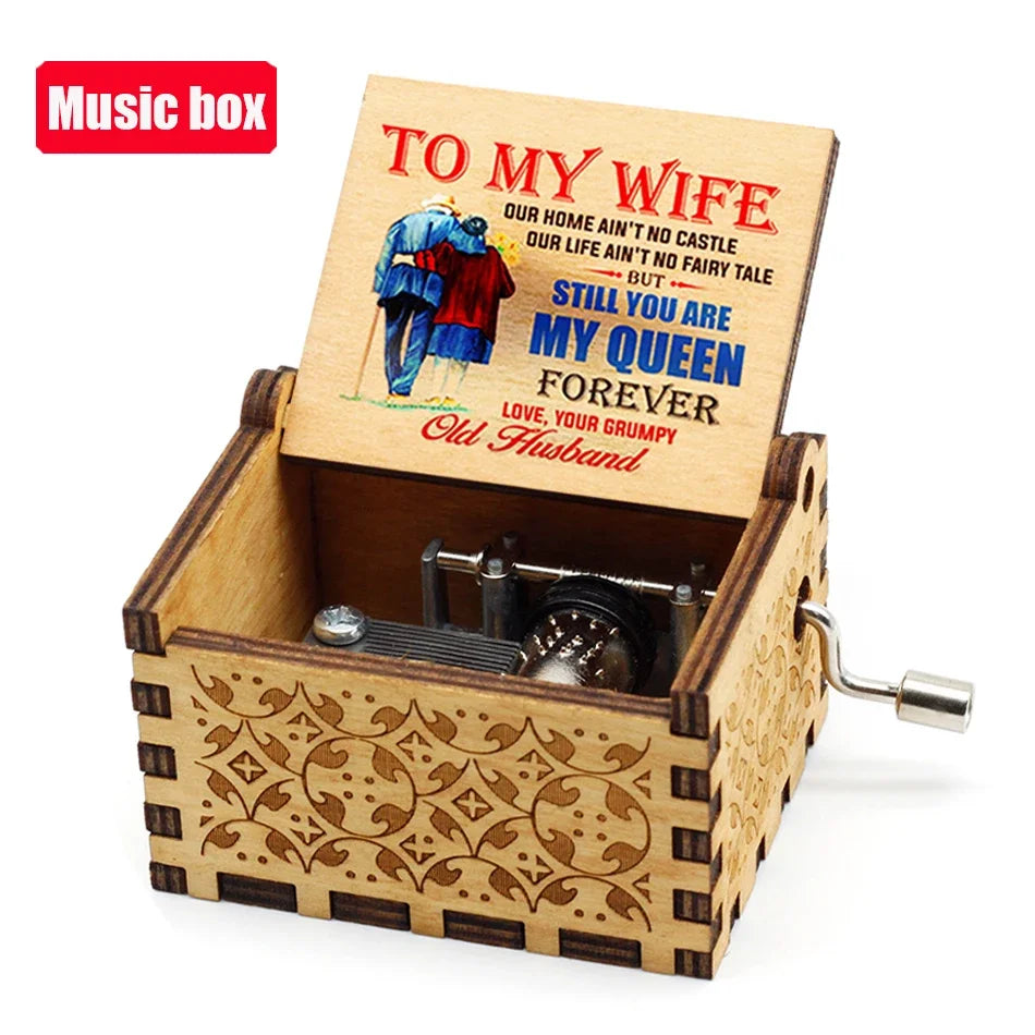 A carved wooden music box with an engraved lid featuring a poem to his wife and a small metal mechanism.