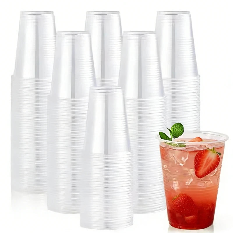 A bulk pack of clear disposable plastic cups and a glass filled with strawberry juice and fruit slices.