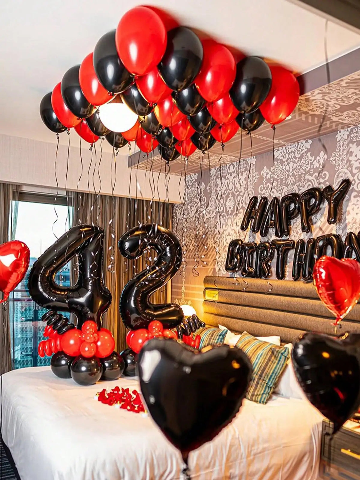 A balloon garland decoration featuring red and black foil number balloons for a birthday celebration.
