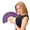 Una joven sostiene un elegante abanico plegable de encaje morado con un borla dorada.