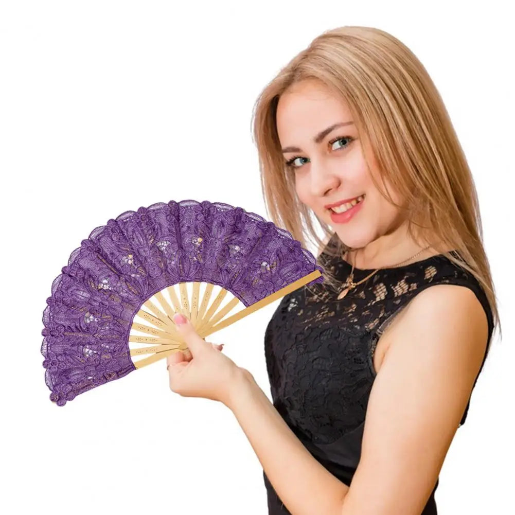 Una joven sostiene un elegante abanico plegable de encaje morado con un borla dorada.