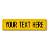 A yellow rectangular metal street sign with the text YOUR TEXT HERE printed on it.