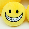 A yellow plush doll with a wide, smiling mouth showing white teeth and black eyes.
