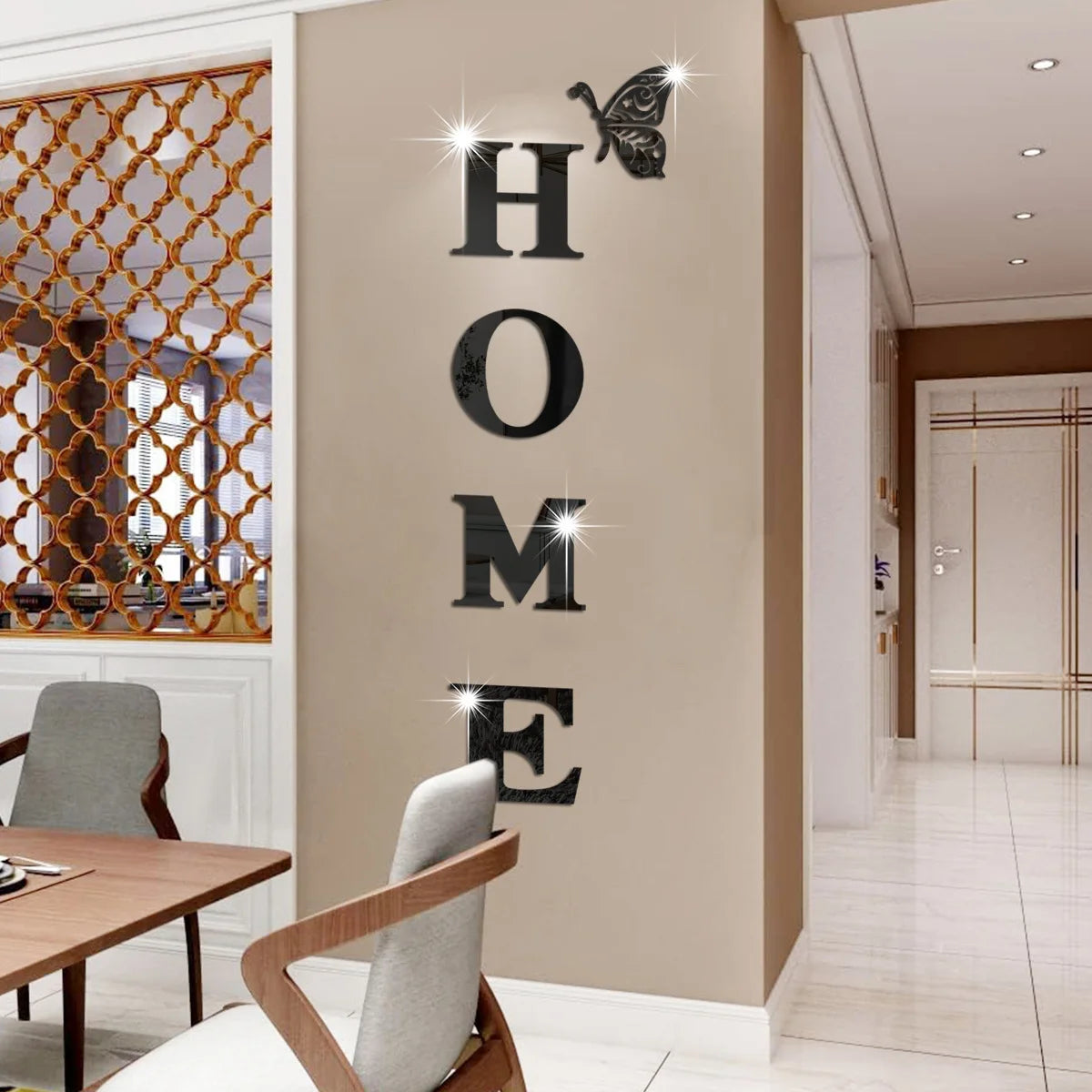 A beige wall features large, metallic butterfly letter decals spelling out HOME.