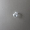 A clear glass fridge magnet shaped like a small, stylized bell or vase is displayed against a gray background.