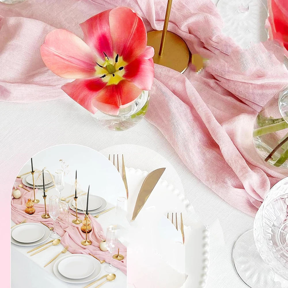 Light blue cheesecloth table runner draped over a pink linen cloth with a floral arrangement.