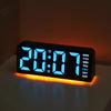 A black digital alarm clock displaying 20:07 with an orange glow on a white surface.