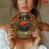 A woman holds a vintage BBQ metal sign featuring a grill and utensils as kitchen decor.