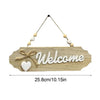 A wooden welcome sign with the word Welcome carved into it and adorned with small white beads on a string.