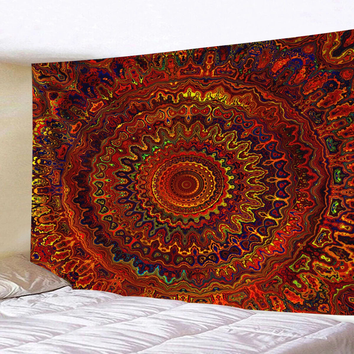 A vibrant, circular bohemian mandala tapestry wall hanging displayed above a bed.