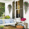 Three faux eucalyptus hanging plants displayed on a white porch with greenery and flowers.