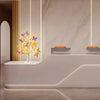 A white modern display featuring a 24-LED butterfly birch tree light with warm glow against a marble wall.